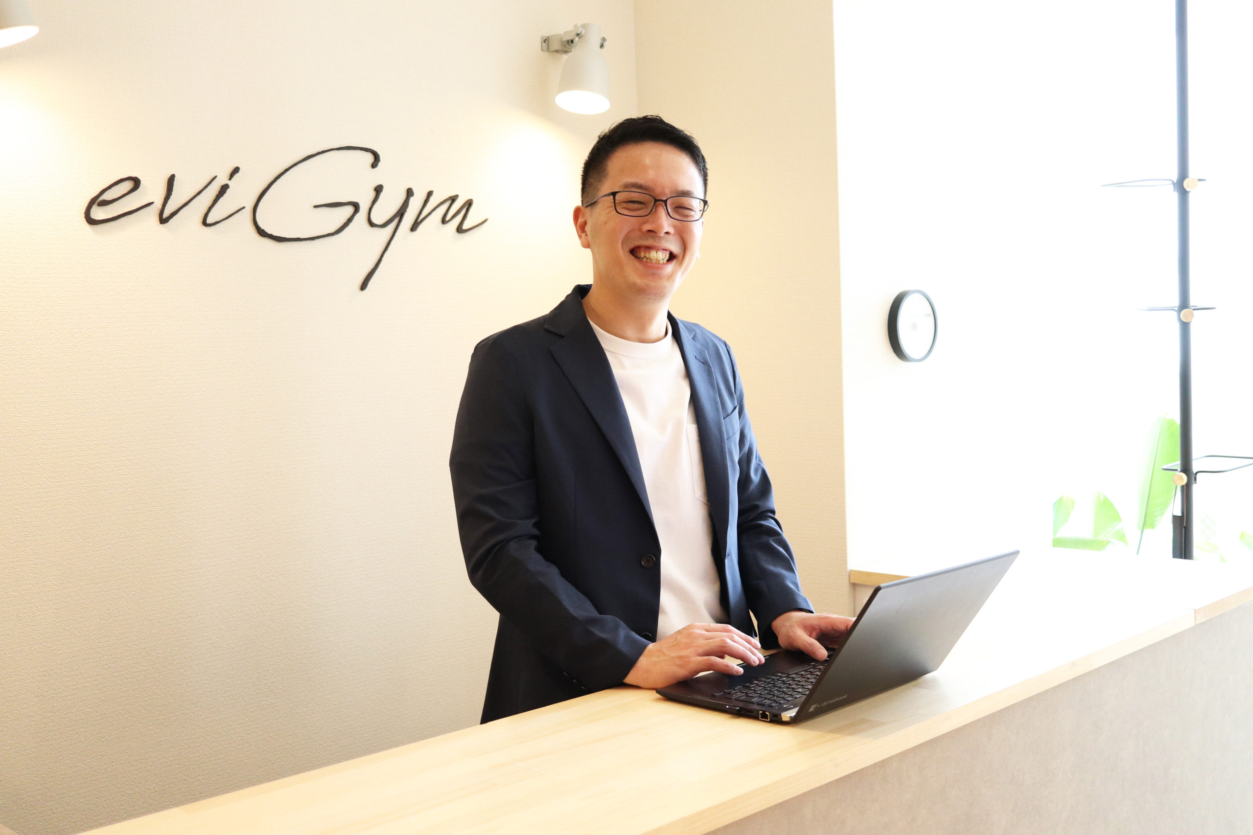 パソコンに手を置いて笑顔を向ける松原さん