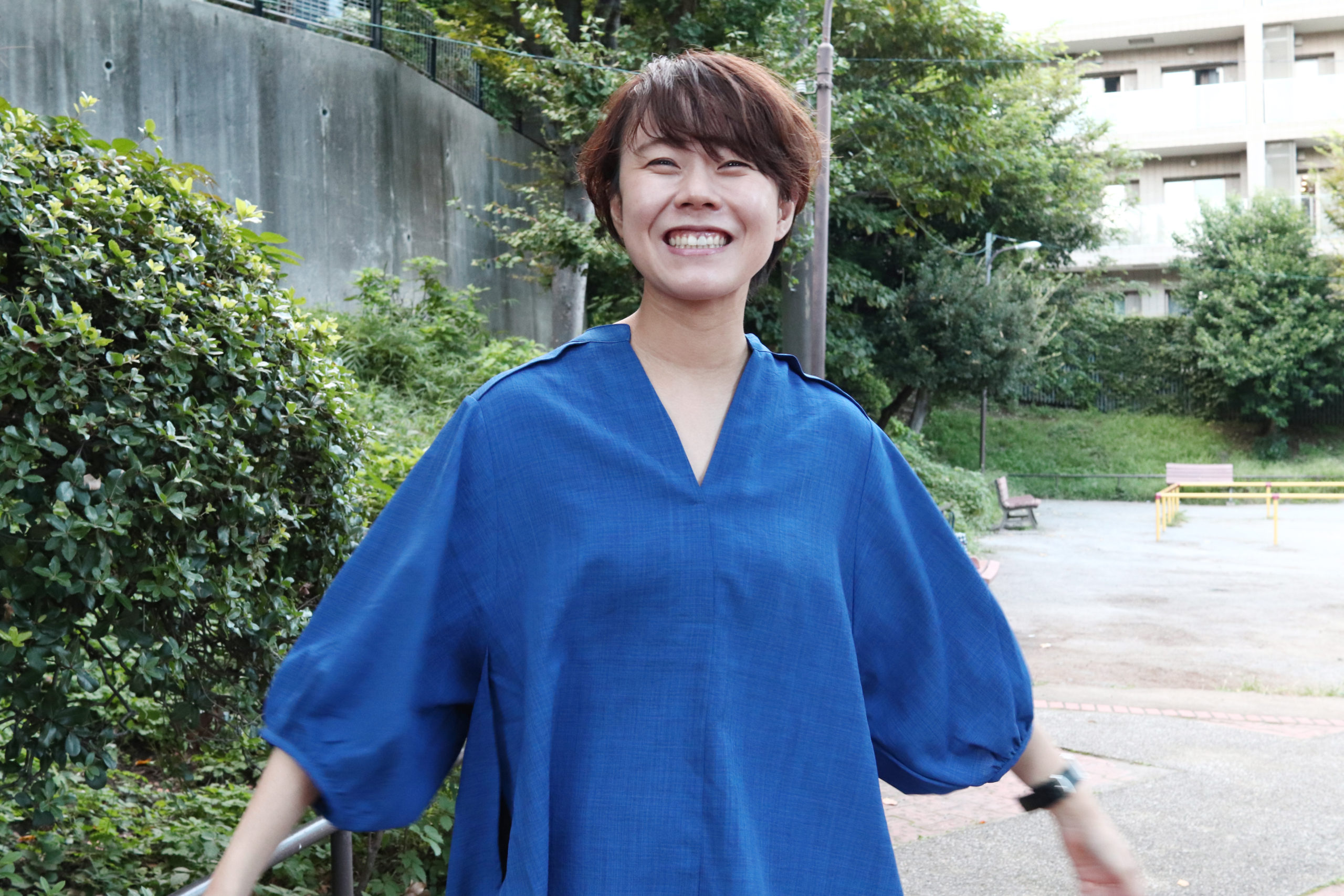 笑顔で手を広げて立っている山田トレーナー