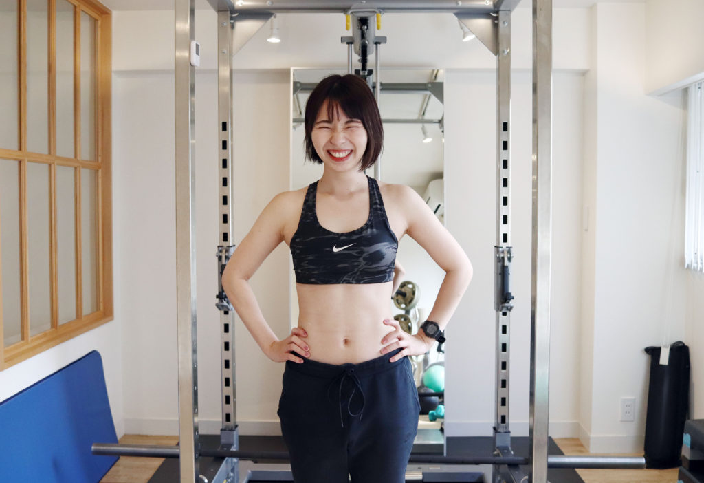 トレーニングウェアを着て笑顔を見せる長谷川トレーナー