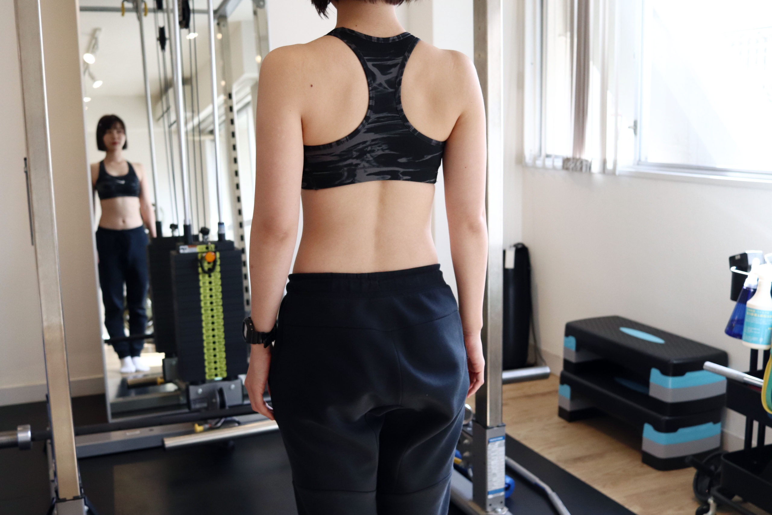 トレーニングウェアを着た長谷川トレーナーの後ろ姿