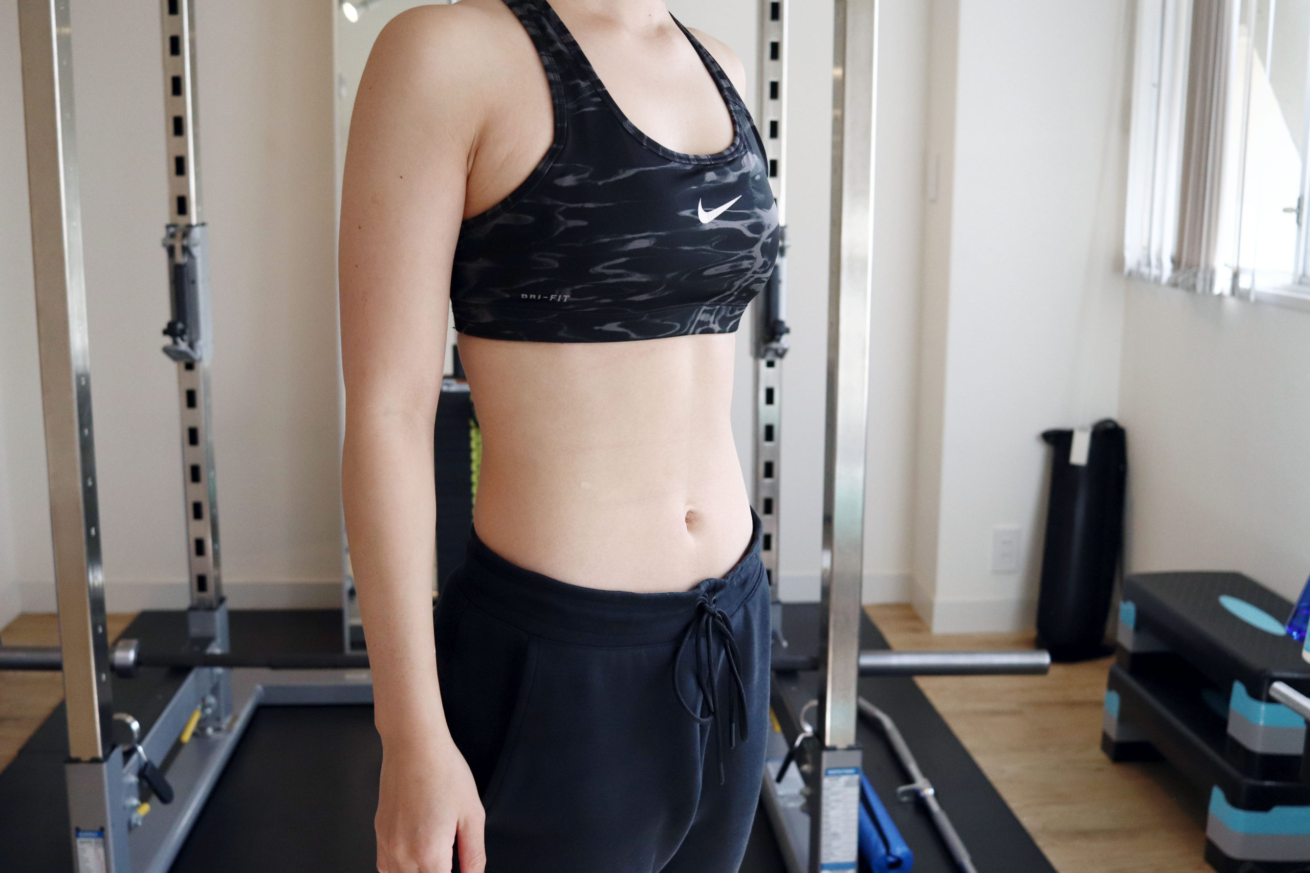 トレーニングウェアを着た長谷川トレーナーの上半身