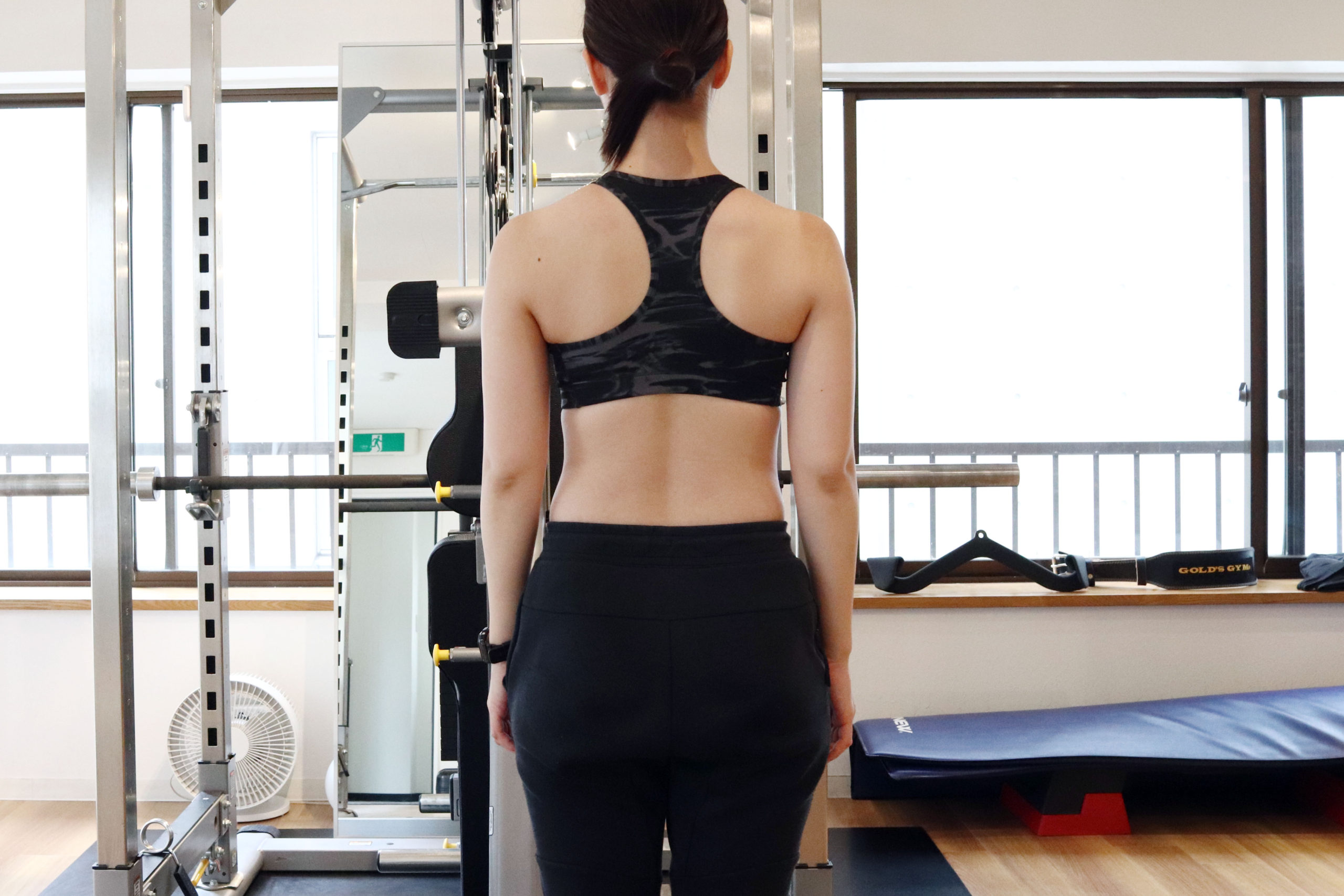 トレーニングウェアを着た長谷川トレーナーの後ろ姿