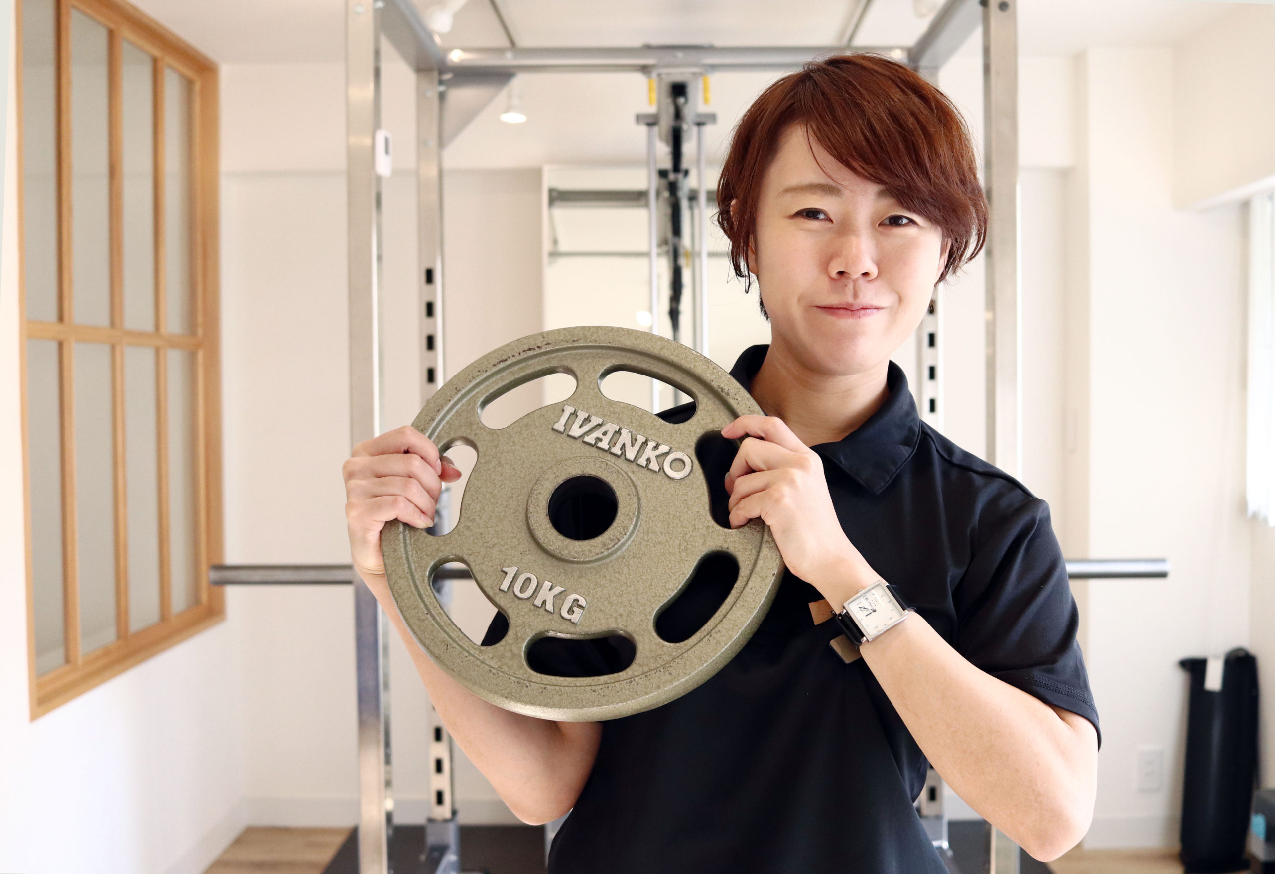 パワーラックの前に立つ山田トレーナー