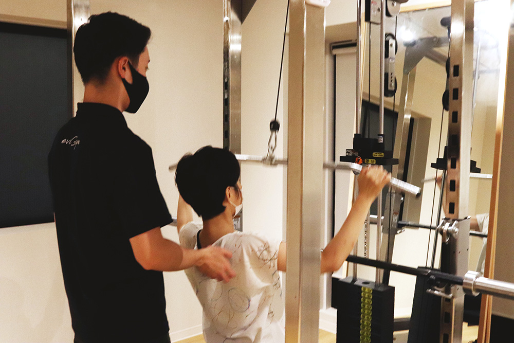 パワーラックに座ってトレーニングしている様子