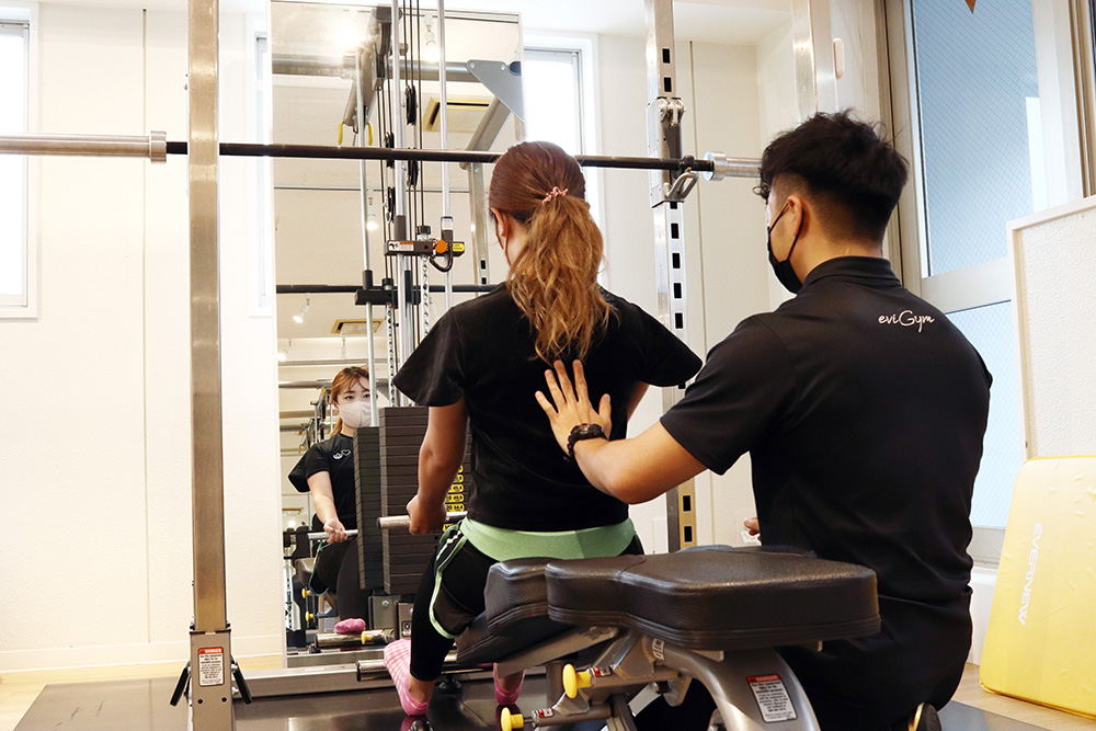 パワーラックに座ってトレーニングしている様子