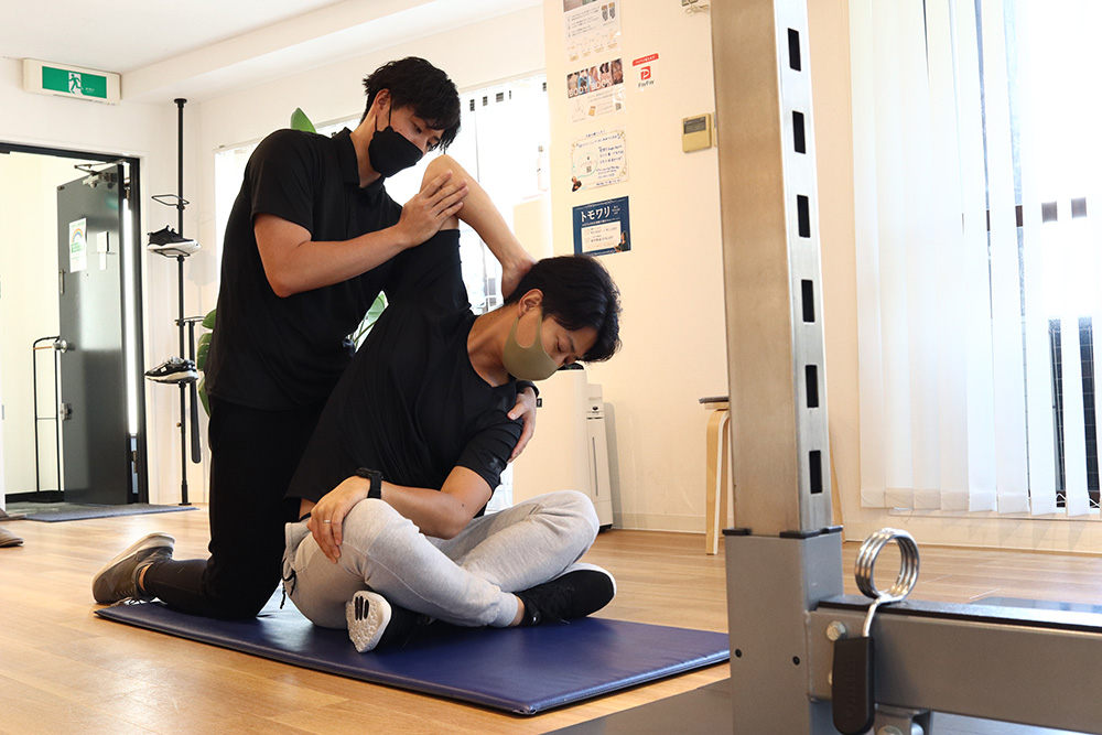 トレーナーがお客様の上半身をストレッチしている様子